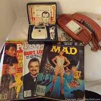 Lot overview showing Sunbeam shaver with original box, ATT Princess phone, and three vintage magazines (People and MAD).