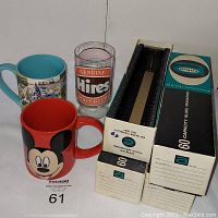 Photo showing all items: two mugs (Mickey Mouse in red, Disneyland themed with blue inside), Hires Root Beer glass, four Argus slide magazines (one box is missing bottom).