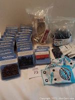 Several packs of Clickclix no sew buttons in plastic packaging along with large bulk bags of button pieces and travel packs.