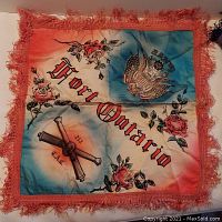 Top side of fringed satin pillowcase with 'Fort Ontario' and military emblems
