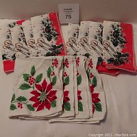 Two sets of Christmas-themed cloth napkins arranged on white surface, showing candy cane and poinsettia designs