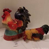 Front and side view of the ceramic Cracker Barrel Break of Dawn Rooster Cookie Jar alongside the resin rooster shelf sitter, showing detail and size.