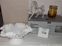 Photo of white ruffled milk glass candy dish, amber vase, Otagiri unicorn figurine on top of boxed set of stemless wine glasses