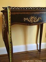 Measurement of table height using tape measure against table leg