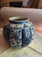 Front angle view of the round blue and white Delft vase showing the floral design and shape.