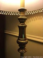 Close up of ornate brass base detailing of the tall lamp.