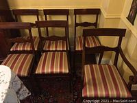 Overview of all six mahogany finish chairs arranged in a row