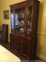Front view of two-piece china cabinet showing glazed display top and lower drawers