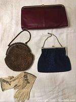 Overview image showing all items in the lot: large leather clutch purse, round brown beaded purse, small navy blue beaded purse, and vintage gloves.