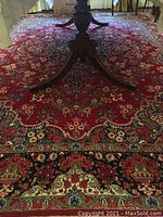 Overhead view of red floral medallion wool rug under pedestal table