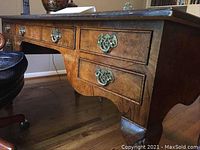 Front right side view of desk showing burl wood veneer drawers and brass hardware