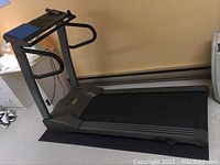 Side view of the entire Vision Fitness treadmill showing the walking belt, handrails, and blue mat underneath.