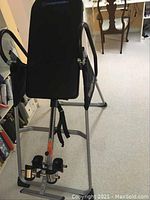 Full front view of inversion table showing padded backrest, frame and handles
