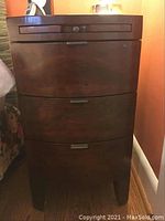 Front view of night table showing three curved drawers: top shallow pull-out tray and two lower drawers.