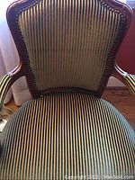 Front view of carved wood frame and striped upholstery