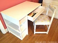 Full view of white-painted kids desk with extended drawers and matching floral cushioned chair in wood
