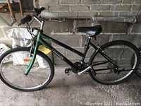 Side view of Precision bike with green and black frame, flat tires, and visible rust on frame and rims.