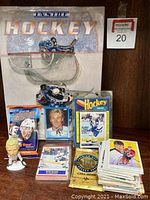 Photo showing large hockey coffee table book 'Inside Hockey' along with unopened hockey card packs and bobblehead figure.