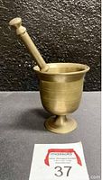 Mortar with pestle resting inside showing side profile and foot base