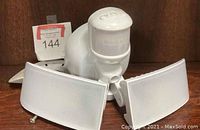 Photo showing white plastic motion detector light with two rectangular adjustable light panels and motion sensor.