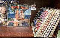 Shelf view showing 'South Pacific' vinyl record prominently with a partial view of Billboard Grammy Voter Guide and other stacked vinyl records.