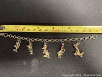 Photo of the full linked chain Disney charm bracelet with all five character charms hanging evenly spaced.