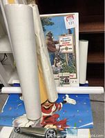 Multiple rolled posters and flat posters including a visible Walt Disney Mickey Mouse poster and a Smokey Bear wildfire prevention poster.