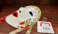 Glossy white ceramic full-face mask with painted Santa Claus faces, bells, and Christmas characters on edges, including red lips and blue eyeshadow.