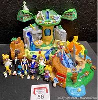 Wide shot showing playset with trees, waterfall, slides, and various figures arranged in front including Sailor Moon characters and Pokémon mini-figures