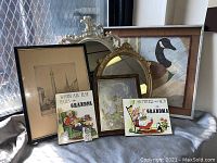 Wide view of all assorted vintage wall art and mirrors showing varied styles, sizes, and subjects, demonstrating lot contents