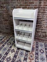 Front angle view of the white Benchmarc store display unit with all shelves pushed in.