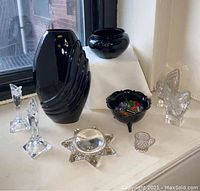 Photo showing full arrangement of all nine items including the large black glass vase, smaller black bowls, crystal candleholders, Murano candy bowl with candies, hobnail miniature creamer, Victorian star magnifier, and tic-tac box for scale.