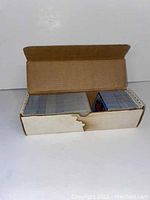 Box open showing multiple packs of baseball cards inside. Water damage visible on box edge.