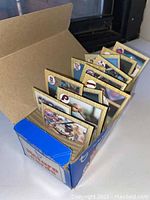 Photo showing open collector box containing multiple upright stacks of baseball cards with visible player images and team logos from 1998 MLB season.