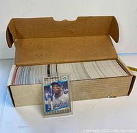 Open box filled with a large number of vintage Fleer Major League Baseball trading cards, showing exterior wear on the cardboard box.