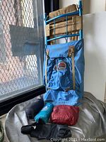 Blue hiking backpack and three small packed bags on floor near window