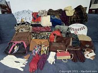 Wide view showing the assortment of purses, scarves, gloves, and hats laid out on a couch.