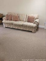 Full view of the 3-seater sofa showing overall shape, fabric pattern, and color, with two pinkish-brown cushions placed on it.