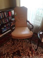 Front view of tan leather armchair showing seat, backrest and wooden frame