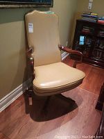 Front view of high-back leather office chair showing seat, backrest and wooden arms