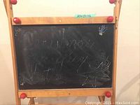 Photo of wooden framed child's chalkboard showing black chalkboard with scribbles and writing. Dimensions 25x17x46 inches.