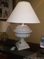 Full view of the white decorative table lamp with fruit design on base and white lampshade