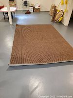 Photo of the brown and taupe carpet laid out flat on the floor, showing texture and color.
