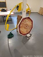 Overall view showing Crokinole game board, yellow putting net, and Spike Ball components grouped on floor