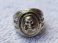 Front view of sterling silver ring showing raised skull and crossbones motif with 'United States Army' text around it.