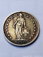 Obverse side of the 1910 Swiss 1 Franc silver coin featuring Helvetia with spear and shield and stars around the edge.