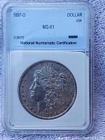 Obverse of 1897-O Morgan Silver Dollar in NNC holder showing Lady Liberty profile and grading label.