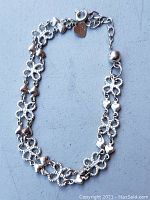 Full view of the double strand sterling silver bracelet showing linked heart and loop chain design.