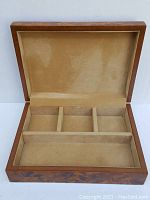 Open view of vintage dresser box showing fabric-lined interior with four compartments (three small, one large)