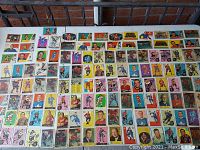 First grid view of approximately 80 cards laid out on table showing various front designs, players and team logos.